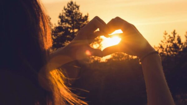 Woman makes heart with hands in sunset. Healthy people  lifestyle. Woman makes heart with hands. Nature lifestyle. Health. Lifestyle. Concept of healthy lifestyle. Happy people. Healthy people. Happiness concept. Young people.